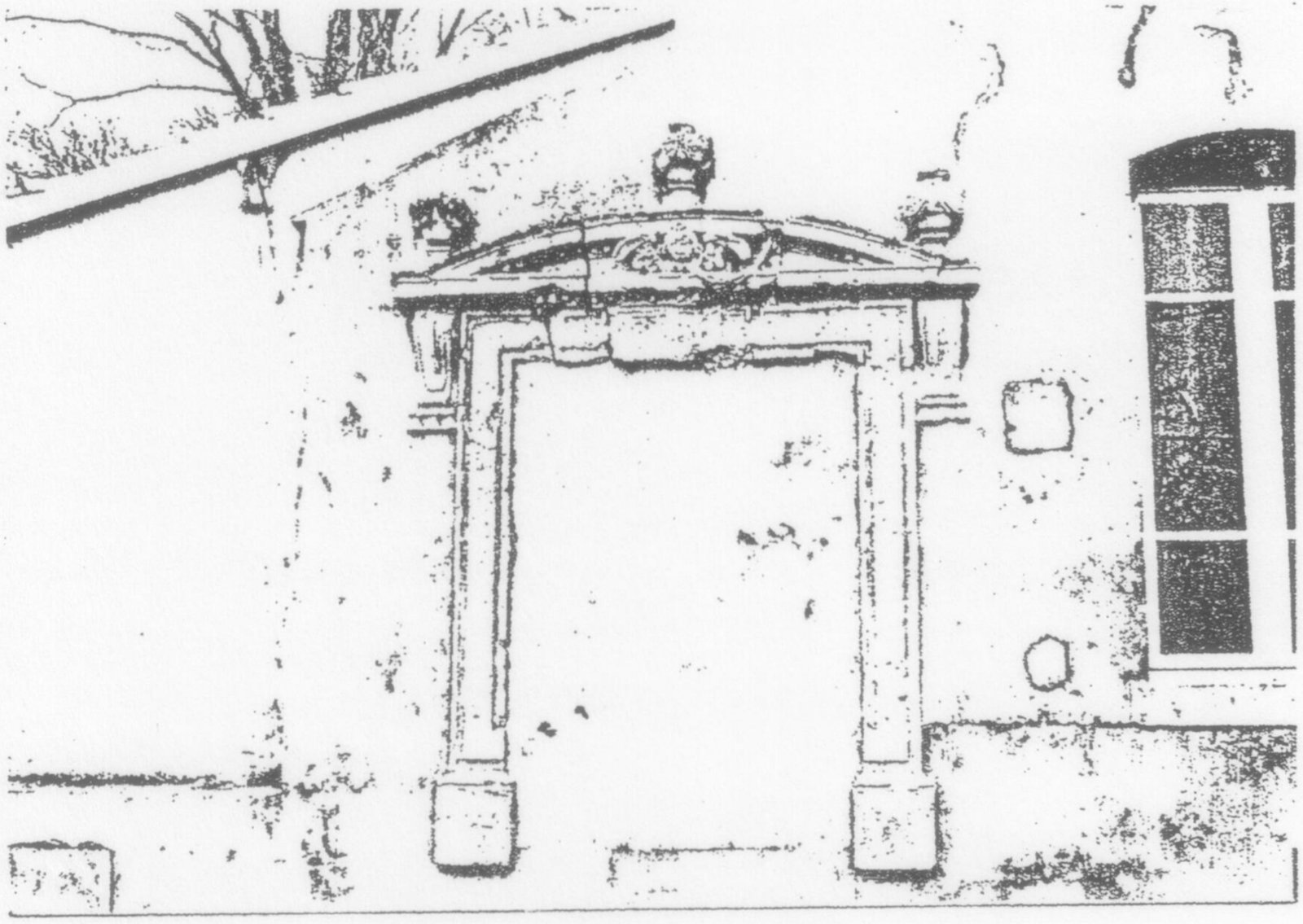 Porche d'entrée en pierre sculptée surmonté d'un fronton, dans un mur, à côté d'une haute fenêtre