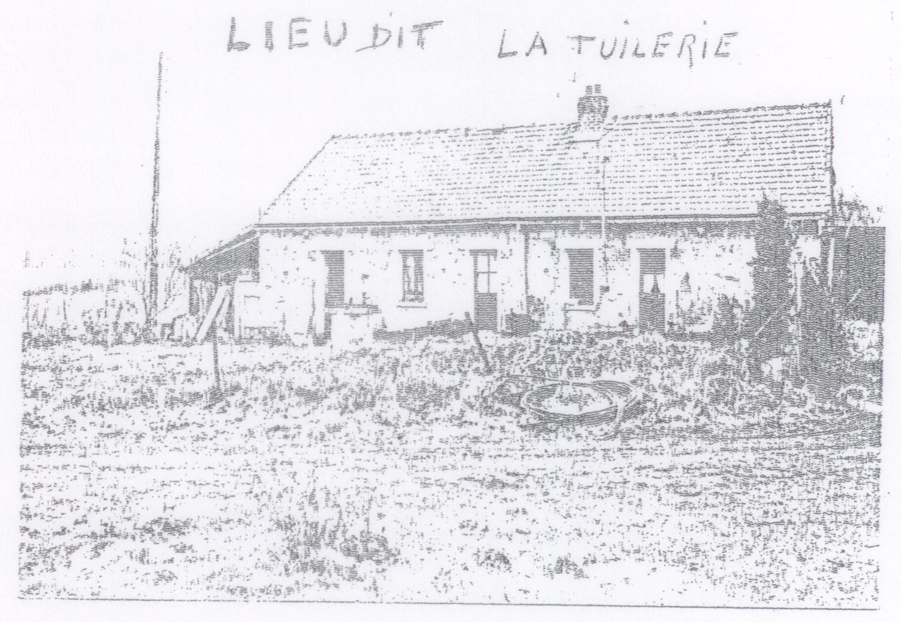 Longue maison basse au toit de tuiles, avec plusieurs portes et fenêtres, devant un terrain en friche